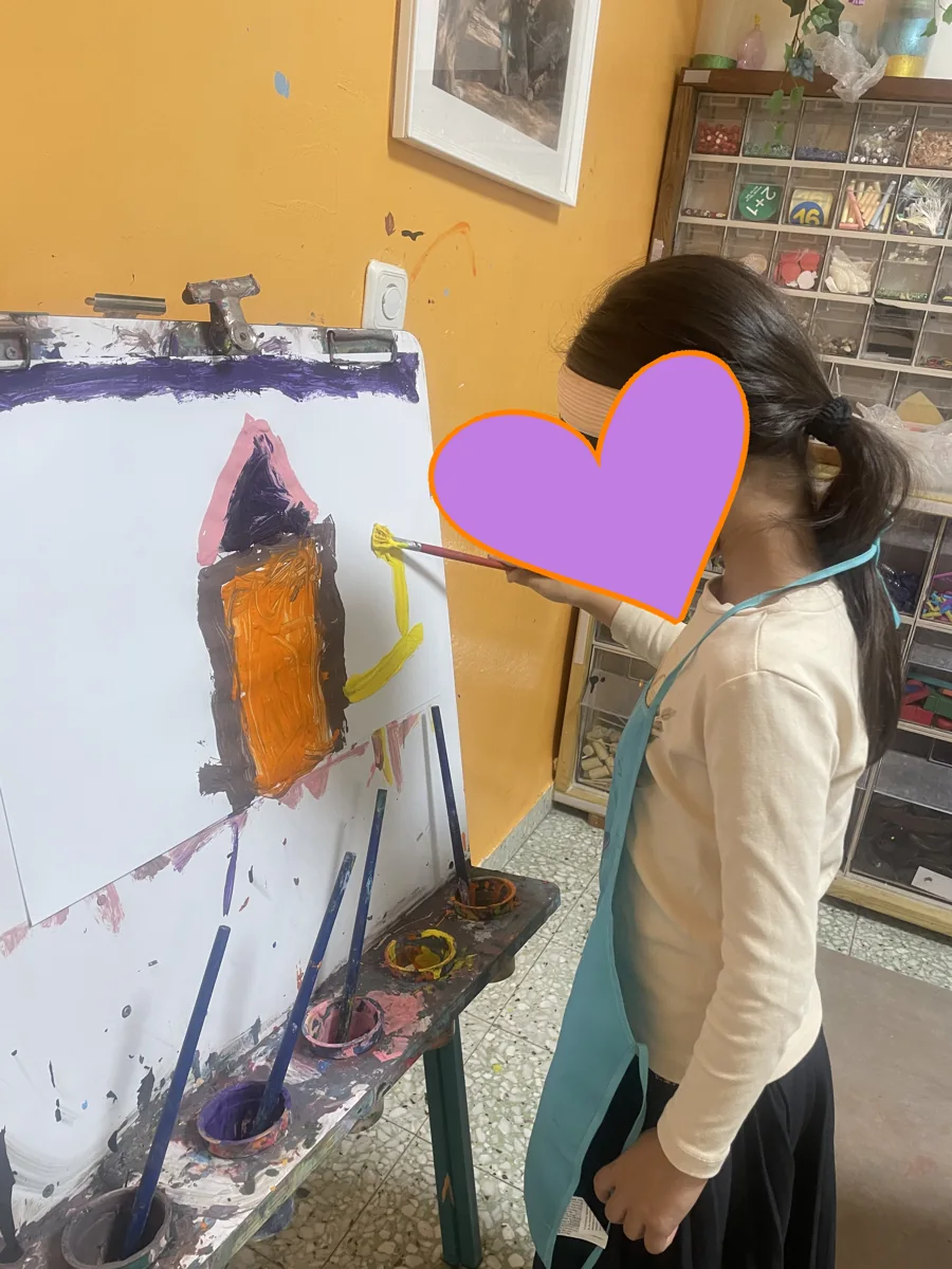 ילדה מציירת בצבעים על כן ציור