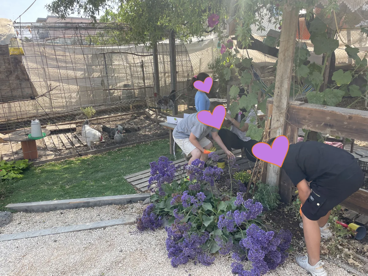 ילדים עובדים יחד בערוגת פרחים